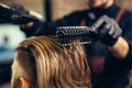 Barber drying male hair in hairdressing salon.