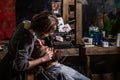 Barber girl shaves his beard with a dangerous razor. Women barber shaves his beard. Barber woman shaving a bearded man Royalty Free Stock Photo