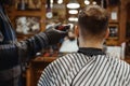 Barber in hat cuts the client `s hair, barbershop