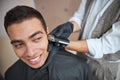 Barber holding electrical machine and making styling of hair and beard Royalty Free Stock Photo