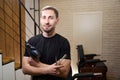 Barber holds hair dryer, scissors and comb in his hands