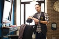 Barber invites to have seat on chair at barbershop