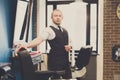 Barber invites to have seat on chair at barbershop