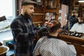 Barber makes a haircut to client, barbershop