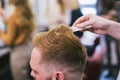 Barber Making Haircut Bearded Man In Barbershop. Professional stylist cutting client hair in salon. Barber using Royalty Free Stock Photo