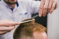 Barber Making Haircut Bearded Man In Barbershop. Professional stylist cutting client hair in salon. Barber using Royalty Free Stock Photo
