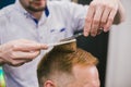 Barber Making Haircut Bearded Man In Barbershop. Professional stylist cutting client hair in salon. Barber using Royalty Free Stock Photo