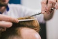 Barber Making Haircut Bearded Man In Barbershop. Professional stylist cutting client hair in salon. Barber using Royalty Free Stock Photo