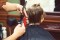 New hairstyle for young boy. Barber shop. Child getting haircut by hairdresser at the barbershop Royalty Free Stock Photo