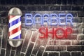 Barber pole on the background of the old brick wall. Neon inscription Barber Shop. Concept Barber Shop.