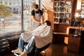 Barber removing unwanted hair from client beard after trimming Royalty Free Stock Photo