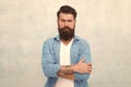 Barber salon. Male beauty concept. Well groomed macho. Brutal handsome hipster man on grey wall background. Bearded man