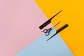 Barber set with two combs and scissors on the color pink, yellow, blue paper background Royalty Free Stock Photo
