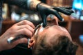Barber shaves the beard by straight razor