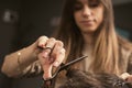 Barber shop men hairstyle. Young man getting a modern haircut. Girl hairdresser cuts a guy with scissors. Men& x27;s Royalty Free Stock Photo
