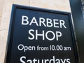 Barber shop sign board with opening hours.