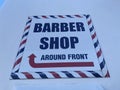 A Barber shop sign red white and blue around front on a wall Royalty Free Stock Photo