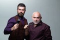 Barber shop. Two men posing with electric razor and blade. Bearded father and son - Barbershop advertising. Royalty Free Stock Photo