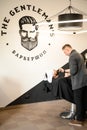 A barber stylist trims the beard of a Caucasian man, whose face is covered with towel, with scissors Royalty Free Stock Photo