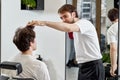 Barber talking to Caucasian man while sitting in chair