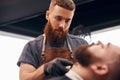 Barber trimming beard of customer Royalty Free Stock Photo