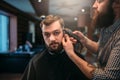 Barber trimming hair of the client man by clipper