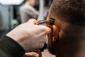 Barber uses trimmer to cut client hair in barbershop Royalty Free Stock Photo