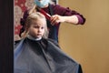 Barber woman make fashionable pretty hairstyle for cute little girl