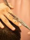 the barber at work. the master cuts his hair with scissors