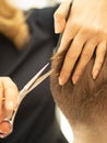 the barber at work. the master cuts his hair with scissors