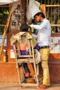 Barber working in the street at Kinari Bazaar, Agra, Uttar Pradesh, India