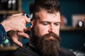 Barbers hand with hair clipper trimming. Stylish haircut concept. Hands of barber with clipper close up. Hipster bearded Royalty Free Stock Photo