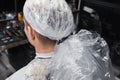 Barbershop client man's head close-up in plastic film professional hair dyeing process