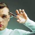 Barbershop concept. Barber glossy hairstyle hold steel scissors. Macho confident barber cut hair. Barbershop service