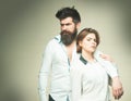 Barbershop concept. Fashion shot of couple after haircut. Woman on mysterious face with bearded man, light background