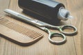 Barbershop concept. Hairbrushes, sprayer and a scissors on a wooden board, selective focus Royalty Free Stock Photo