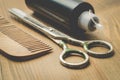 Hairbrushes, sprayer and a scissors on a wooden board, selective focus Royalty Free Stock Photo