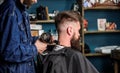 Barbershop concept. Hipster bearded client got hairstyle. Barber with hairdryer blows off hair out of cape. Barber with Royalty Free Stock Photo
