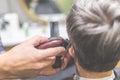 Barbershop. Hairdresser does hairstyle with hair clipper and comb Royalty Free Stock Photo