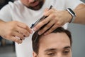 Barbershop worker carefully performing a fresh haircut for a man Royalty Free Stock Photo