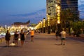 Barcelona - coastline with beach during evening and night, people on promenade, lights and hotels