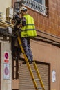 Barcelona, EspaÃÂ±a - Abril 10, 2022. Workman climbing on a ladder installing telephone and fiber line in the street