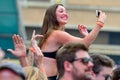 A woman taking a picture with her phone from the audience at Sonar Festival