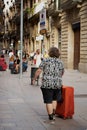 Barcelona - June 11, 2023: Vibrant Adventures Await: Tourist with a Red Suitcase Exploring the Streets of Barcelona