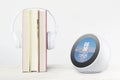 BARCELONA, MAY 30: Alexa Echo Spot device on a self next to some books and headphones.