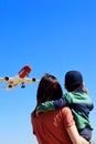 Mother and little two years old son enjoy their time watching large airplanes landing in Barcelona.