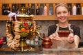 Barcelona, Spain - April 5, 2016: Attractive young woman give cup of tea in transparent glass prepared with russian traditional tr