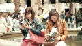 BARCELONA, SPAIN - APRIL, 16, 2017. Two young women reading city tourist guide books near the fountain