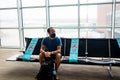 Barcelona, Spain - 20 august 2020: young man sit alone inside airport with face mask and social distancing sign, traveling in the Royalty Free Stock Photo