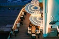 Lounge promenade deck on cruise ship. Interior of luxury cruise restaurant with tables and armchair in sunset at sea Royalty Free Stock Photo